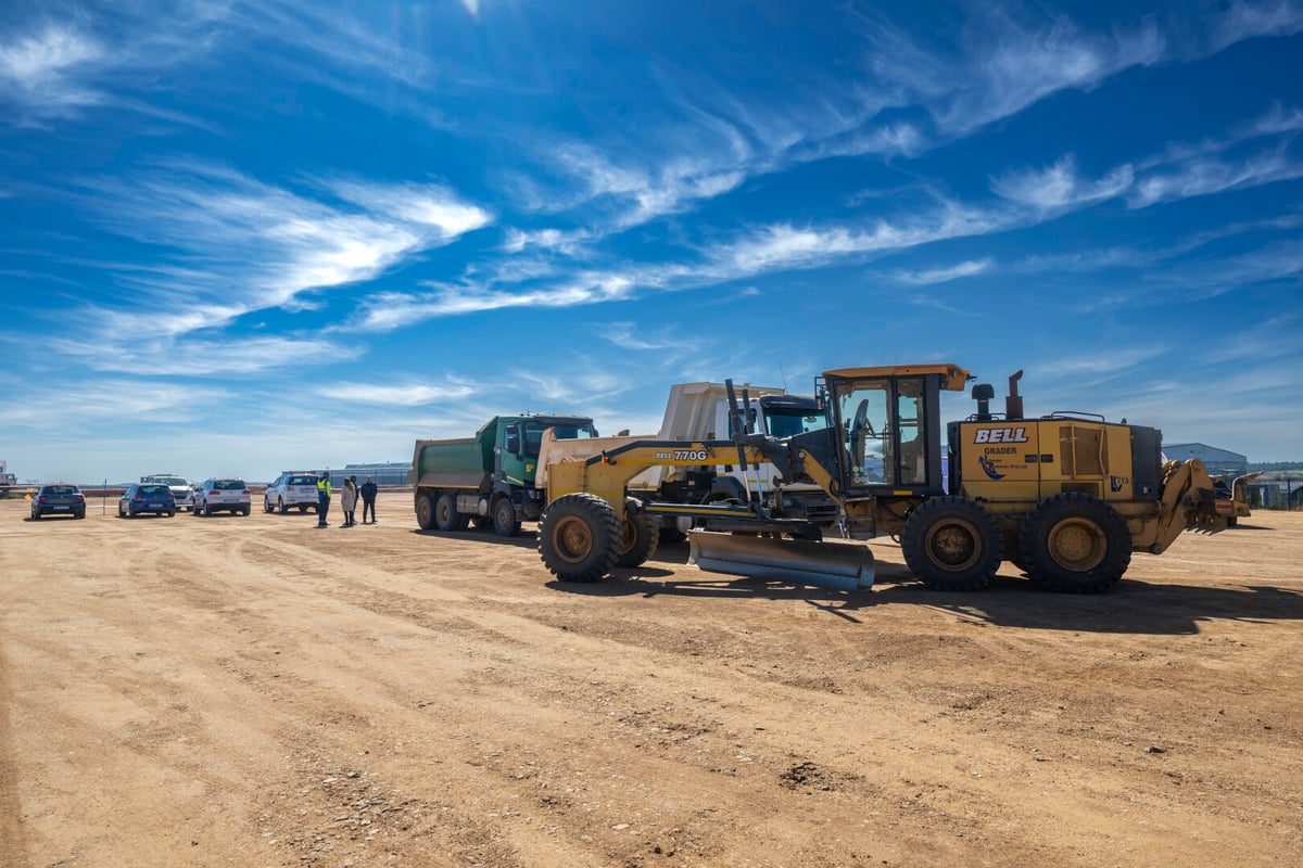 Tractors on construction site with Suzuki vehicles in the background.